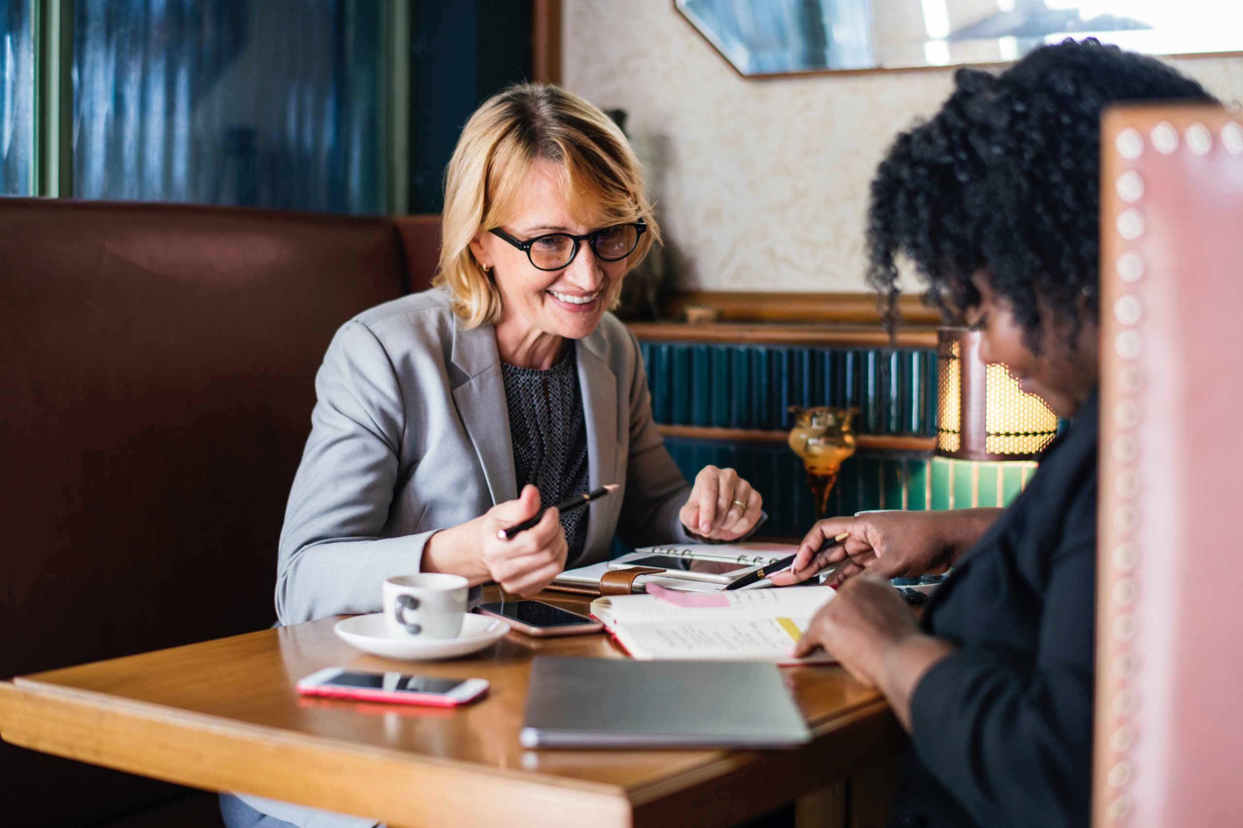 Two business women at a table having a meeting.